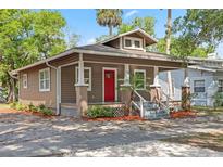 Charming bungalow-style home features a red front door and a welcoming front porch at 216 S Holly Ave, Sanford, FL 32771