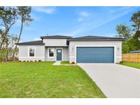 Charming single-Gathering home with a well-manicured lawn, blue accents, and a two-car garage at 443 Marion Oaks Crse, Ocala, FL 34473