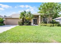 Charming single-story home with well-manicured lawn, lush landscaping, and double-door entry at 1124 Shadowbrook Trl, Winter Springs, FL 32708