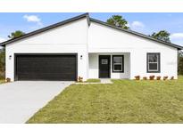 New construction home features a black garage door and a well manicured lawn at 14961 Sw 38Th Cir, Ocala, FL 34473