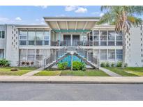 Charming condo with striking blue accents and lush landscaping, offering a welcoming facade and curb appeal at 151 N Orlando Ave # 115, Winter Park, FL 32789