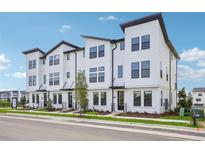 Charming white townhomes feature modern design, black accents, and manicured landscaping in a vibrant community at 15483 Hamlin Park Drive, Winter Garden, FL 34787