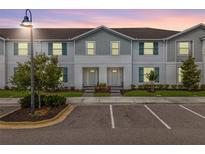 Charming townhome with neat landscaping, gray siding, and blue shutters at 2432 Tangier Dr, Kissimmee, FL 34747