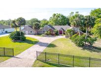 Beautiful exterior home features well-manicured lawn, a red door and palm trees at 2836 S Stewart St, Kissimmee, FL 34746