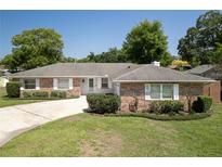 Charming single-story brick home featuring manicured landscaping and a concrete driveway at 3029 Peel Ave, Orlando, FL 32806