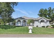 Elegant single-story home with arched entryway, well-manicured lawn, and lush landscaping at 392 Bayberry Dr, Polk City, FL 33868