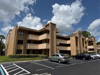 Beige two-story condo building with balconies and parking at 510 Cranes Way # 206, Altamonte Springs, FL 32701