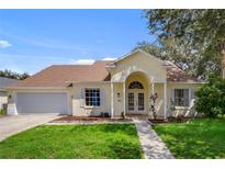 Charming one-story home with attached garage, well-manicured lawn, and inviting entryway at 581 Hollingshead Loop, Davenport, FL 33896