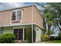 Charming exterior of a townhome featuring classic architecture and lush landscaping around the property at 6021 Village Cir # 6021, Orlando, FL 32822