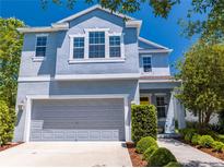 Charming two-story home featuring a gray garage, yellow door, and well-manicured landscaping at 6807 Habitat Dr, St Cloud, FL 34773