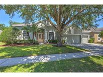 Charming single-story home featuring lush landscaping and a spacious three-car garage at 7167 Winding Lake Cir, Oviedo, FL 32765