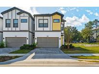 Modern townhome showcasing a two-car garage, neutral paint, and a meticulously designed exterior at 10436 Ebb Tide Lane, Orlando, FL 32821