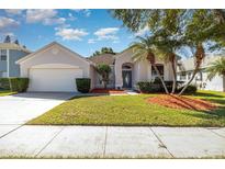 Charming single-story home featuring a well-manicured lawn, palm trees, and a two-car garage at 12213 Bohannon Blvd, Orlando, FL 32824