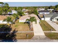 Charming single-story home with lush landscaping, a long driveway, and a two-car garage at 1632 Lansfield Ave, Deltona, FL 32738
