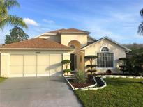 Charming home featuring a manicured lawn with decorative landscaping and a two-car garage at 2507 Hikers Ct, Kissimmee, FL 34743