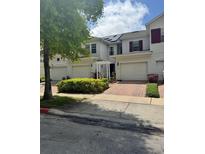 Well-maintained townhouses boast brick driveways, attached garages and manicured landscaping at 3181 Capri Isle Way, Orlando, FL 32835