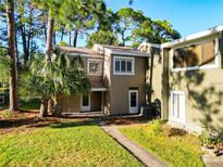 Inviting home exterior featuring a well-maintained lawn and beautiful trees providing shade at 6021 Windhover Dr # F11, Orlando, FL 32819