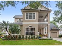 Stunning two-story home featuring a charming front porch and manicured lawn at 6037 Caymus Loop, Windermere, FL 34786