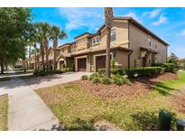 Charming townhouse exterior showcasing the attached garages, manicured landscaping and inviting curb appeal at 8925 Azalea Sands Ln # 602, Davenport, FL 33896