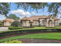 Stunning home exterior displays manicured landscaping, decorative shrubs, and a tiled roof at 13025 Water Point Blvd, Windermere, FL 34786