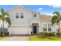 Charming two-story home with a two-car garage, well-manicured lawn, and decorative palm trees at 2036 Lelani Cir, Davenport, FL 33897