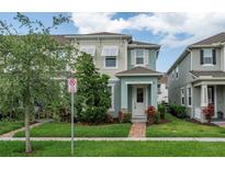 Inviting townhome exterior featuring a well-maintained lawn and colorful landscaping enhancing the property's appeal at 2214 Centerra Loop, Kissimmee, FL 34741