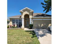 Charming single-Gathering home featuring a well-manicured lawn and attached two-car garage at 2445 Cypress Trace Cir, Orlando, FL 32825