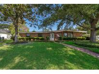 Charming brick home featuring a lush green lawn, mature trees, and a welcoming front entrance at 2609 Chinook Trl, Maitland, FL 32751
