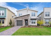 Charming two-story home with stone accents, landscaped yard, and modern design at 2771 Oxymoron Way, Kissimmee, FL 34746