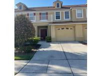 Charming townhouse featuring a balcony, two-car garage, and well-maintained landscaping at 3111 Wentworth Ln, Kissimmee, FL 34741