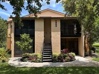 Inviting exterior with well-maintained landscaping and access stairs to the upper level units at 4800 S Semoran Blvd # 101, Orlando, FL 32822