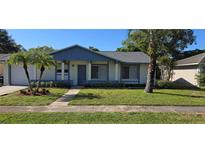Charming single-story home with manicured lawn, garden beds, and a walkway leading to the front door at 4906 Gifford Blvd, Orlando, FL 32821