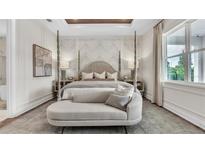 Beautiful main bedroom boasts tray ceilings, a four-poster bed, and a sitting area with lots of light from the windows at 52 Overleaf Ln, Orlando, FL 32839