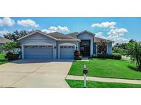 Charming single-story home with a well-manicured lawn and a three-car garage at 543 Auburn Hill Blvd, Auburndale, FL 33823