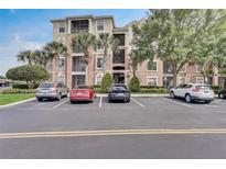Exterior view of a three-story condo building with palm trees and parking at 8296 Portofino Dr # 103, Davenport, FL 33896