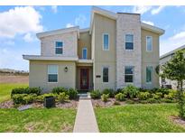 Contemporary two-story home boasts a stone accent wall and well-maintained landscaping at 9084 Sommerset Hills Dr, Davenport, FL 33896