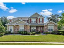 Charming two-story home featuring stone accents, red shutters, and a beautifully landscaped front yard at 1065 Cavan Dr, Apopka, FL 32703