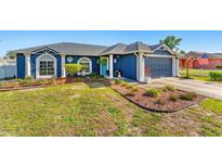 Charming blue single-story home with a well-maintained front yard and an attached garage in a desirable neighborhood at 20321 Majestic St, Orlando, FL 32833