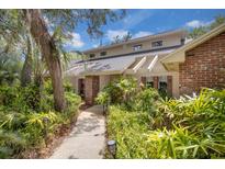 Inviting home exterior with brick accents, lush landscaping, and mature trees at 204 Green Lake Cir, Longwood, FL 32779