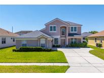 Two-story home showcasing neutral stucco, well-manicured lawn and mature shrubbery at 2340 Hinsdale Dr, Kissimmee, FL 34741