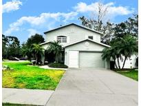 Charming two-story home with a well-manicured lawn and mature landscaping at 1309 Harms Way, Port Orange, FL 32129