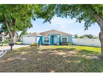 Charming single-story home with blue exterior, well-maintained lawn, and a two car garage at 134 Foggy Creek Ct, Davenport, FL 33837