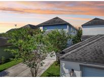 Two-story home featuring light blue siding, a gray roof, and mature landscaping at 13890 Sato Ave, Orlando, FL 32827