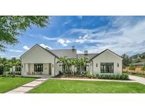 Stunning exterior showcasing a modern white home with a metal roof and lush landscaping at 1400 Nottingham St, Orlando, FL 32803