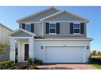 Charming two-story home featuring a two-car garage, gray siding, and a well-manicured front yard at 14647 Crestavista Dr, Clermont, FL 34714
