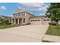 Spacious driveway leading to a three-car garage with a well-maintained lawn at 1710 Alejo Dr, Apopka, FL 32712