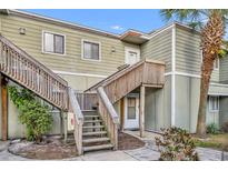 Charming two-story condo featuring a wooden staircase and a lush palm tree at 186 Scottsdale Sq # 186, Winter Park, FL 32792