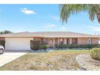 Charming brick home with a two-car garage and well-maintained landscaping at 2102 E Atmore Cir, Deltona, FL 32725