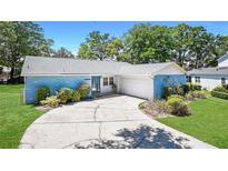 Charming single-story home featuring a blue brick exterior, well-maintained landscaping, and a paved driveway leading to the garage at 222 Paul Mcclure Ct, Casselberry, FL 32707