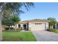 Charming single-story home with tile roof, stone accents, well-manicured lawn and brick paver driveway at 307 Monterey St, Kissimmee, FL 34759
